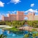 The exterior of the Atlantis Paradise Island reveals a body of water next to a grand multi story hotel with palm trees